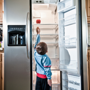 hungry boy reaching into fridge